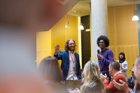 Conference audience clapping for male speakers