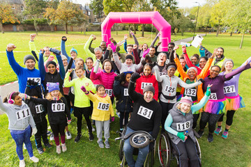 Portrait crowd  of runners cheering at charity run in park