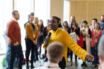 Audience listening to female speaker with microphone