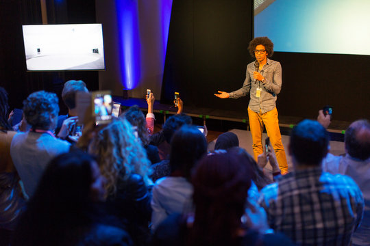 Male speaker with microphone talking to audience