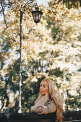 A woman sitting on the bench in the park in the afternoon.