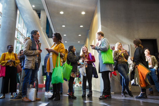 Business people with bags talking at conference