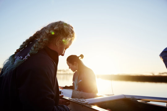 Female Rowers Preparing Scull At Sunrise Lakeside