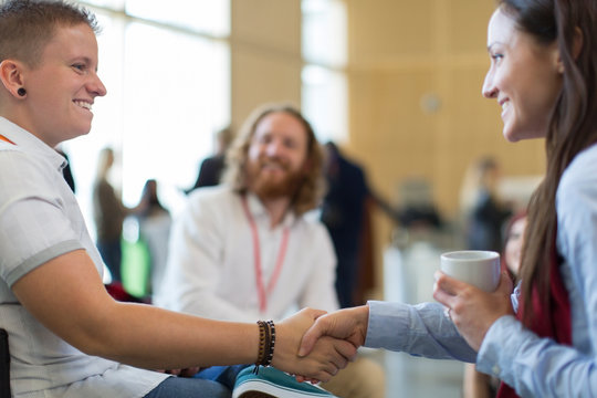 Businesswomen shaking hands at conference