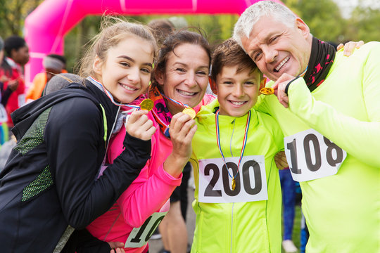 Portrait smiling, confident family runners showing medals at charity run