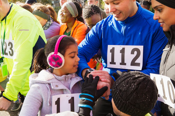 Family runners checking smart watch at charity run starting line