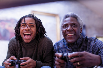 Enthusiastic grandfather and grandson playing video game