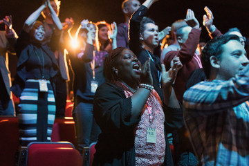 Audience clapping and cheering in dark concert hall
