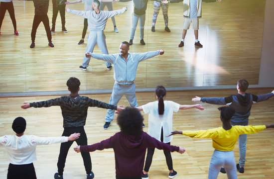 Male instructor leading dance class in studio