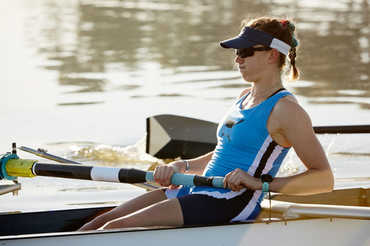 Determined female rower rowing scull