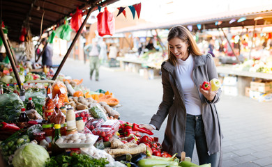A woman choosing peppers at the farmer's market.