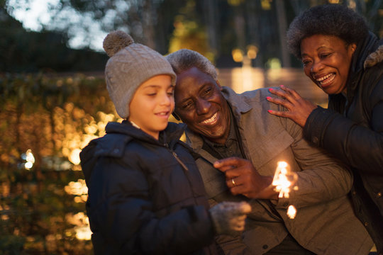 Grandparents and grandson playing with firework sparkler