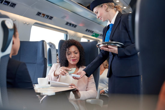 Businesswoman smart phone using contactless payment, paying attendant on passenger train