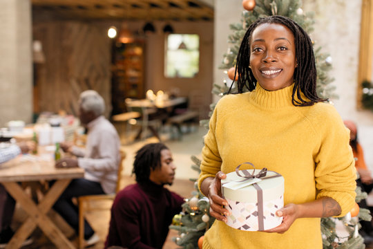 Portrait smiling, confident woman holding Christmas gift