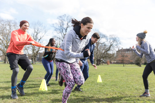 People racing, doing team building exercise in sunny park