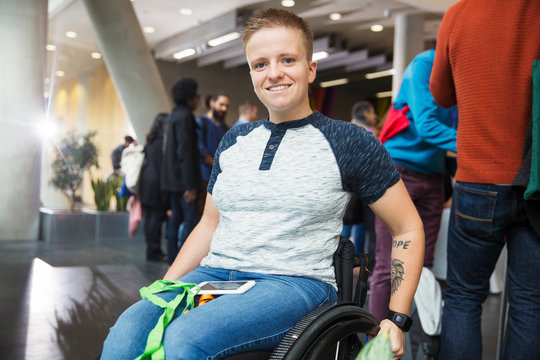 Portrait smiling young woman in wheelchair at conference