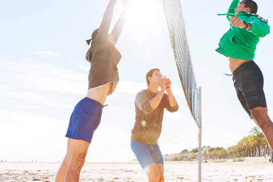 Men Playing Beach Volleyball On Sunny Beach