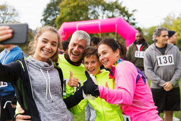 Enthusiastic family runners taking selfie at charity race