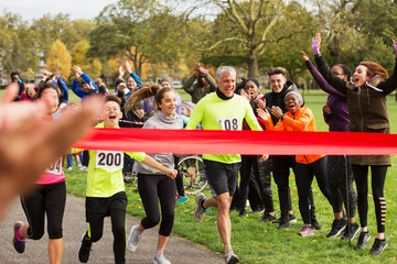 Enthusiastic family running, nearing charity run finish line in park