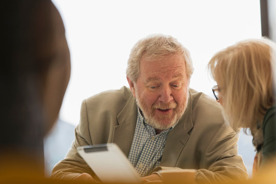 Senior business people using digital tablet in meeting