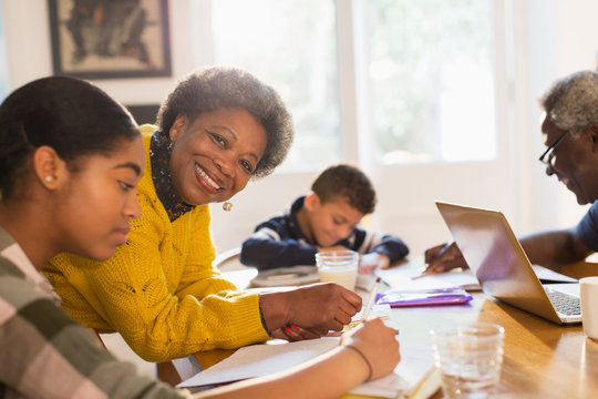 Portrait smiling, confident grandmother helping granddaughter homework