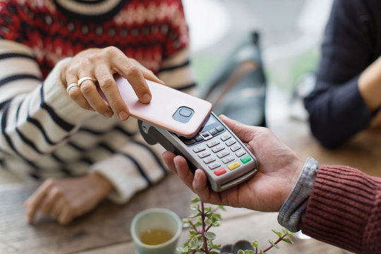 Woman with smart phone using contactless payment