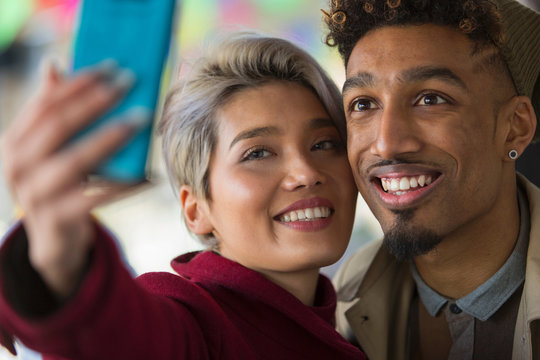 Smiling young couple taking selfie with camera phone