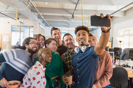 Creative business team taking selfie in office