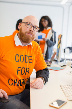 Portrait confident hacker coding for charity at hackathon