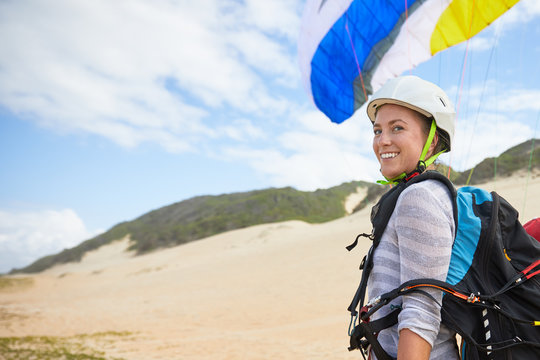 Portrait smiling, confident young female paraglider on beach