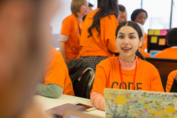 Hackers at laptop coding for charity at hackathon
