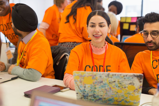 Hackers at laptop coding for charity at hackathon
