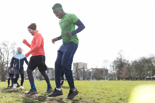 Men doing speed ladder drills in sunny park