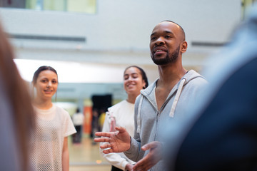 Male instructor leading discussion in dance class studio