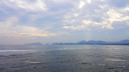 cloudy sky over the pacific ocean. Bright sunset sky over the surf waves in the ocean. rays of the sun through the clouds on the surface of the sea, reflection