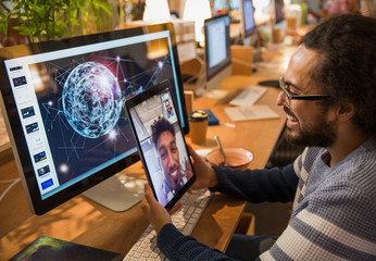 Graphic designer video chatting colleague on digital tablet in office