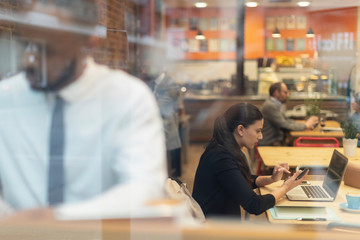 Focused businesswoman working at laptop in cafe