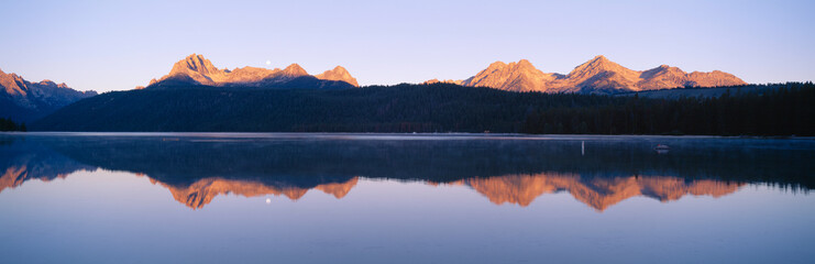 Moonset at sunrise over Redfish Lake and Sawtooth Mountains, Idaho