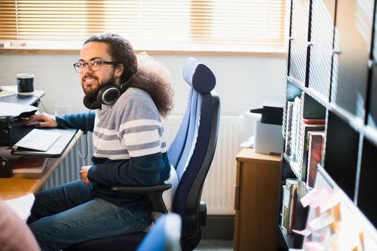 Portrait smiling, confident creative businessman headphones working in office