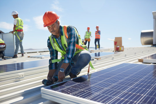 Engineer installing solar panels at sunny power plant