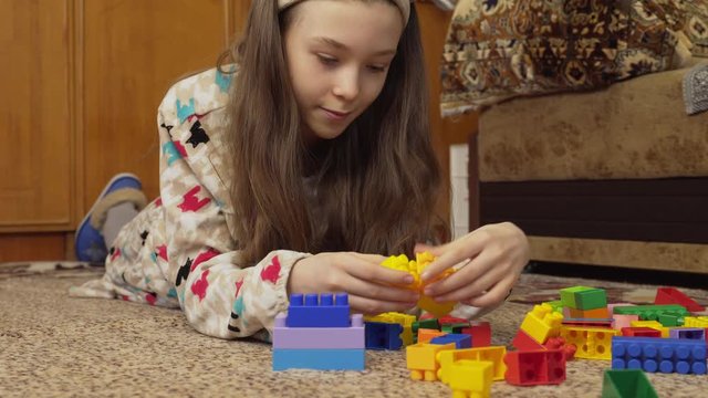 girl assemble a color constructor from blocks