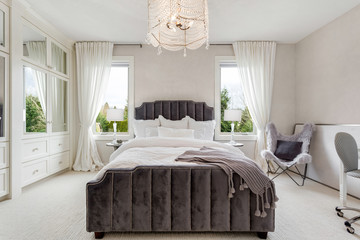 Bedroom in new luxury home with chandelier and elegant furnishings