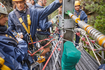 People preparing zip line equipment