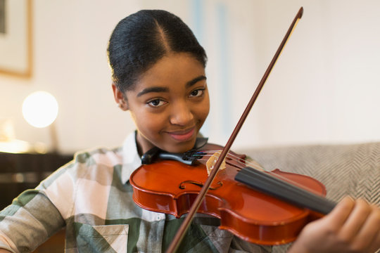 Portrait confident teenage girl playing violin