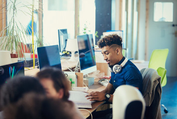 Creative businessman working at computer in open plan office