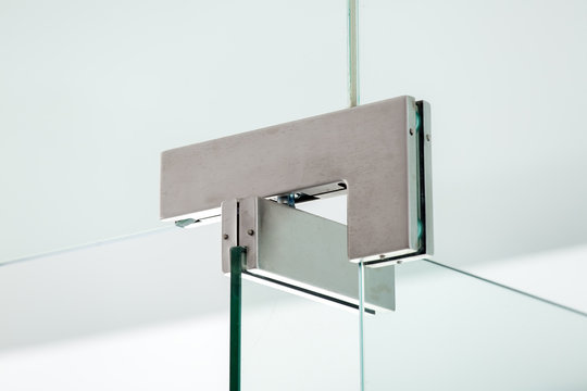 glass door hinges metal fittings with door locking mechanism, close up.