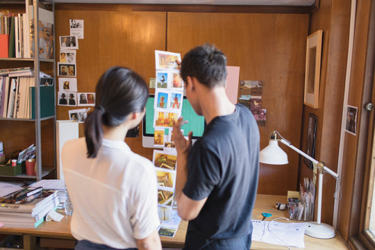 Creative designers reviewing photograph proofs in office
