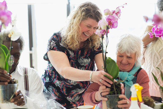 Smiling instructor and senior woman in flower arranging class