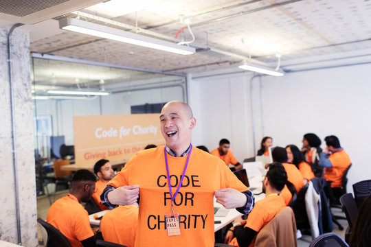 Playful hacker with t-shirt coding for charity at hackathon