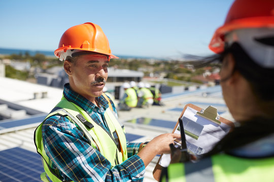 Engineers discussing paperwork at alternative energy power plant